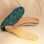 Pair of custom foot orthotics with patterned tops