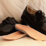 Custom foot orthotics shown with dress shoes