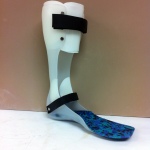 White plastic ankle foot orthosis with strap